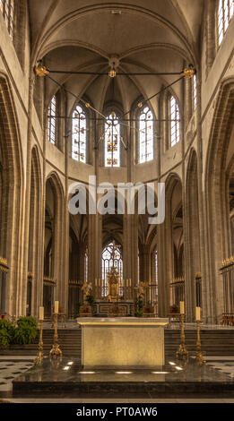 Dunkerque, France - September 16, 2018: Inside Saint Eloi church shows chancel with high ceiling and two altars. Brown environment. Light through high Stock Photo