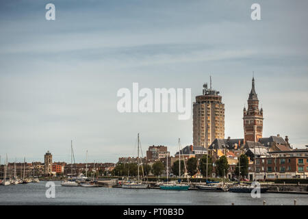 Dunkerque, France - September 16, 2018: Old Port with sailing yachts and three towers, LTR: Leughenaer historic lightower, condominiums, Belfry of Dun Stock Photo