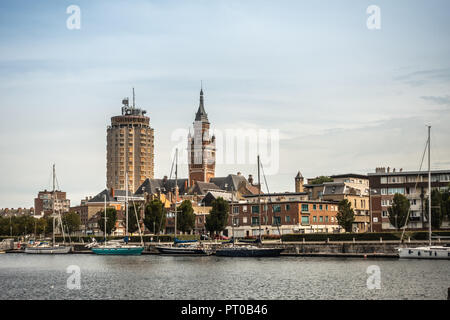 Dunkerque, France - September 16, 2018: Old Port with sailing yachts and two towers: condominiums, Belfry of Dunkirk town hall under light blue sky. R Stock Photo