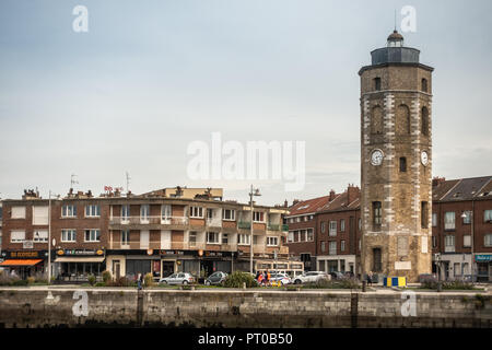 Dunkerque, France - September 16, 2018: Leughenaer brick Clock tower and historic lighthouse on Minck Square at old port of Dunkirk. Street scene with Stock Photo