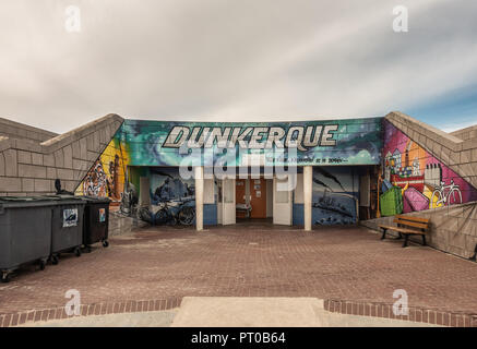 Dunkerque, France - September 16, 2018: Colorful wall paintings of Public toilet facilities on boardwalk along Dunkirk beach. Brown stone walls. White Stock Photo