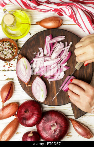 Hands cut red onions. Ingredients for onion chutney, marmalade, confiture,  jam. Selective focus Stock Photo