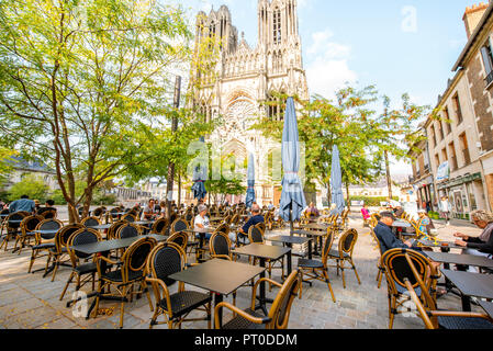 REIMS, FRANCE - August 27, 2017: View on the square with cafe bar near the famous Notre-Dame cathedral in Reims city, France Stock Photo