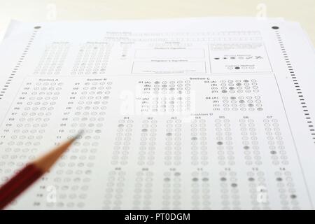 Picture of OMR sheet and pencil. Exam OMR sheet circles is filled with pencil. Isolated on white background. Stock Photo
