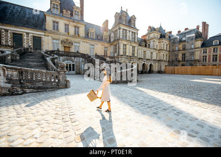 FONTAINBLEAU, FRANCE - August 28, 2017: Woman walking near the beautiful staircase visiting famous Fontainebleau palace in France Stock Photo