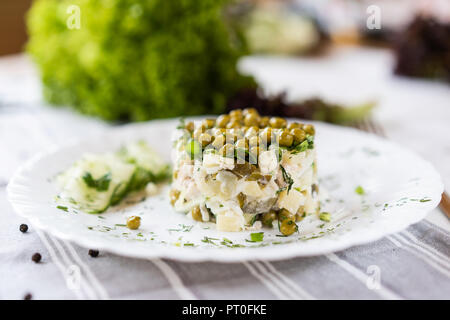 Russian National food. Traditional salad Olivie. Eating concept. Bright green background for text and design. Stock Photo