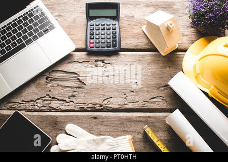 Engineer and home construction concept, house model, blue print and working tools of architecture on dark wood table background Stock Photo