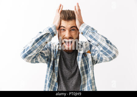 Portrait of an annoyed young bearded man standing isolated over white, screaming Stock Photo