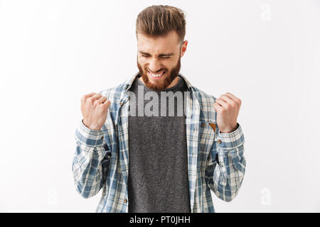 Portrait of a happy young bearded man standing isolated over white, celebrating success Stock Photo
