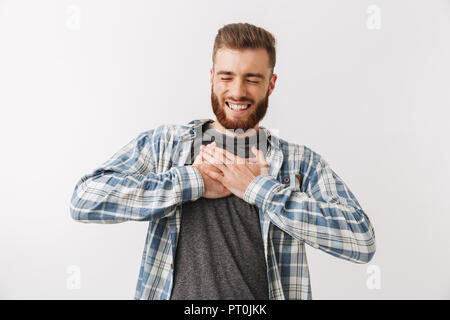 Portrait of a satisfied young bearded man standing isolated over white, celebrating success Stock Photo