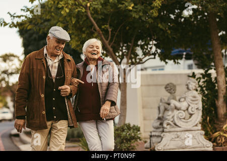 Senior couple walking outdoors on winter day. Elderly man and woman in warm clothing walking together on street. Stock Photo