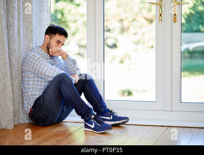 Stressed man sat on the floor Stock Photo