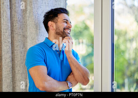Man looking out of window happy Stock Photo