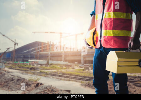Construction worker or technician  holding tools box and helmet at soft blur working site background, ready to repair and fix concept Stock Photo