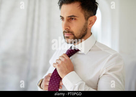 Man adjusting his tie Stock Photo