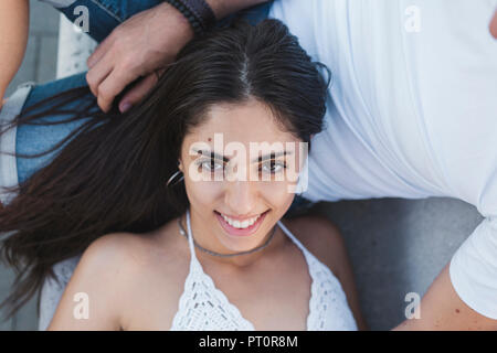 Happy young woman lying on lap of her boyfriend, portrait Stock Photo