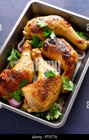 Roasted chicken legs in baking tray. Tasty dish for dinner Stock Photo