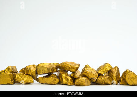 A pile of gold nuggets or gold ore isolated on white background, precious stone or lump of golden stone, financial and business concept idea. Stock Photo