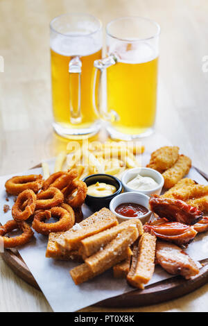 Large portion of snacks and 2 glasses of light beer Stock Photo