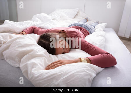 Young Woman Sleeping On Bed In Bedroom Stock Photo