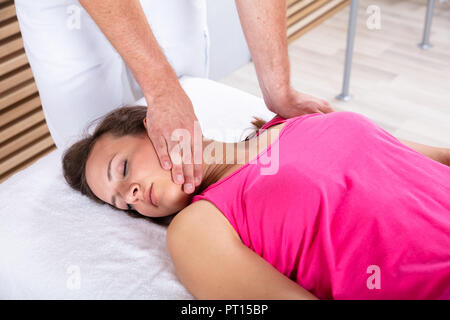 Close-up Of A Therapist's Hand Giving Massage To Relaxed Young Female Stock Photo