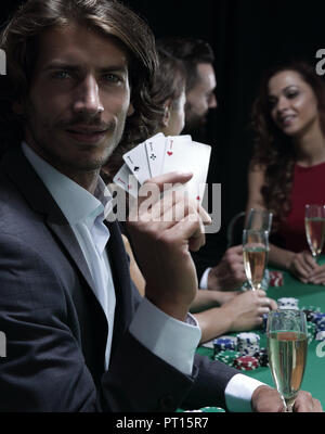 Poker players in casino with cards and chips on black background Stock Photo