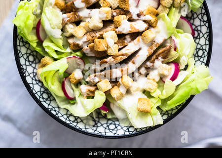 Bowl of Caesar salad with meat and red radish