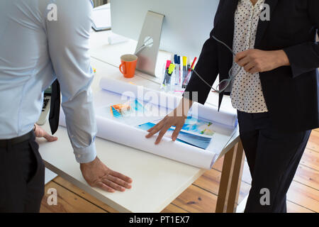 Businessman and businesswoman with printouts in office Stock Photo