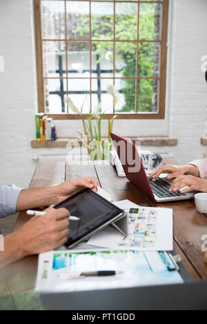 Mature couple working from their home office, using laptop and digital tablet Stock Photo