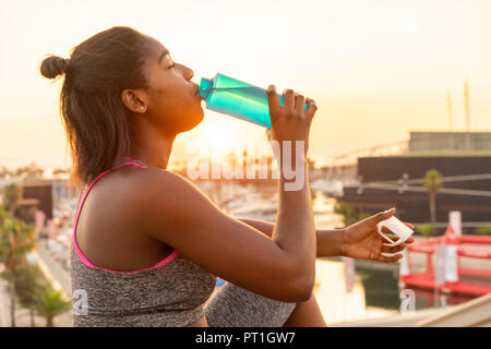 Young woman drinking water during work out Stock Photo