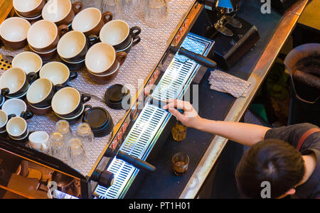 Unrecognisable barista making coffee at coffee machine in shop. Top aerial view Stock Photo