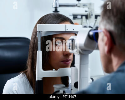 Optometrist examining young woman's eye Stock Photo