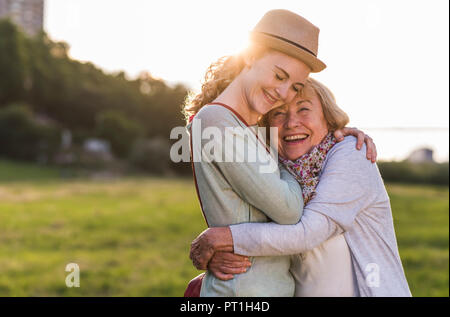 Happy grandmother and granddaughter hugging each other Stock Photo