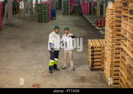 Workers having a conversation in factory Stock Photo