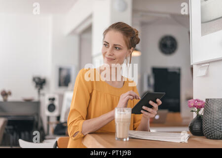 Young woman working in coworking space, using digital tablet Stock Photo