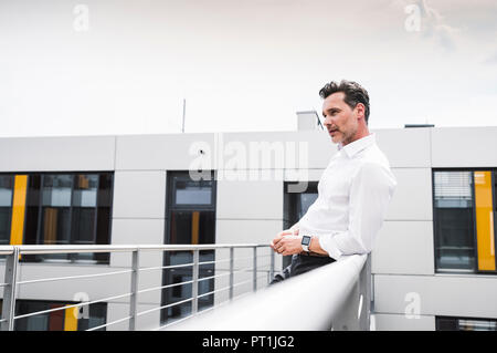 Businessman on skywalk at office building Stock Photo