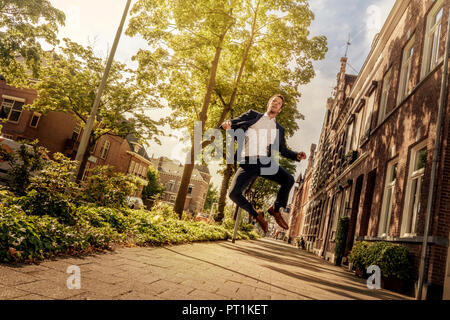 Netherlands, Venlo, businessman jumping on pavement Stock Photo