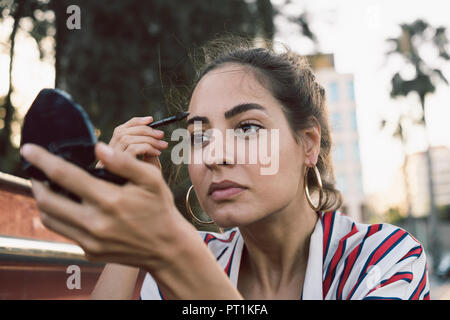 Portrait of woman applying mascara Stock Photo