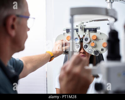 Optometrist examining young woman's eye Stock Photo