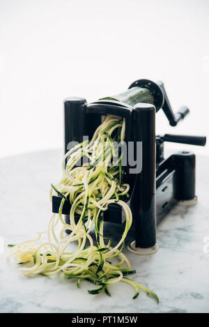 Making zucchini noodles, zoodles, spiral vegetable slicer Stock Photo