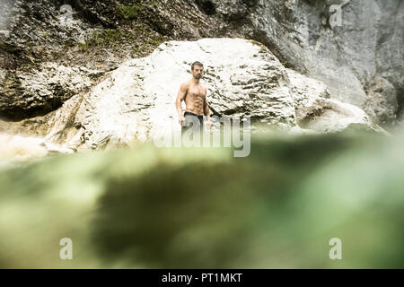 Athletic man standing in water of a brook Stock Photo
