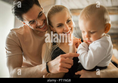 Happy young parents spending time at home with their baby girl Stock Photo