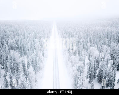 Elevated view of road along the snow covered forest, Pallas-Yllastunturi National Park, Muonio, Lapland, Finland Stock Photo