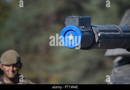 Augustdorf, Germany. 5th Oct 2018. A soldier wearing camouflage paint standing behind a tank cannon with a British muzzle protector during a signing ceremony. Defence Minister von der Leyen and her British counterpart signed a 'Joint Vision Statement', a bilateral declaration on closer cooperation in security and defence matters. Photo: Ralf Hirschberger/dpa Credit: dpa picture alliance/Alamy Live News Stock Photo