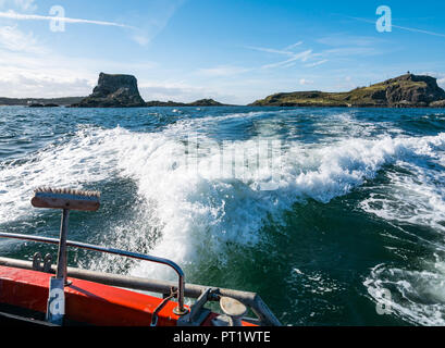 Fidra Island, Firth of Forth, Scotland, United Kingdom, 5th October 2018. Boat wake speeding in sea looking towards rock called The Castle on the Island on sunny day with wispy clouds and blue sky Stock Photo