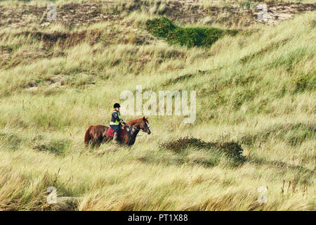 Merthyr Mawr, Wales UK. 5th October 2018. A Horse and rider enjoy the late afternoon sun and calm weather in the sand dunes at Merthyr Mawr, Wales UK. Credit: Phillip Thomas/Alamy Live News Stock Photo