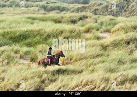 Merthyr Mawr, Wales UK. 5th October 2018. A Horse and rider enjoy the late afternoon sun and calm weather in the sand dunes at Merthyr Mawr, Wales UK. Credit: Phillip Thomas/Alamy Live News Stock Photo