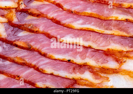 Close-up of appetizing slices of smoked bacon. With baking paper. Stock Photo