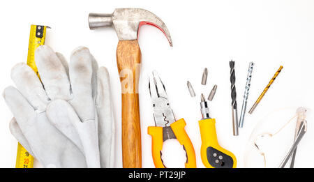 Various construction tools. Isolated on white background. Homemade DIY Hammer, gloves and safety glasses, meter, pliers, screwdriver, bits. Stock Photo