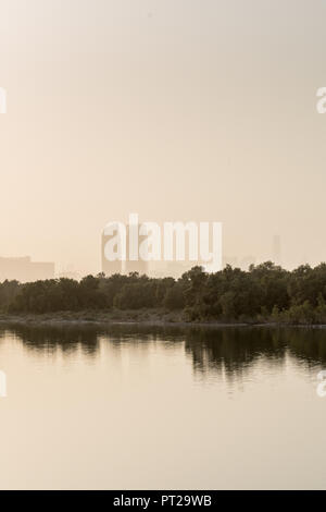 27 August 2018: Al Bahr Towers and Mangroves reflection in the sea, Abu Dhabi UAE Stock Photo